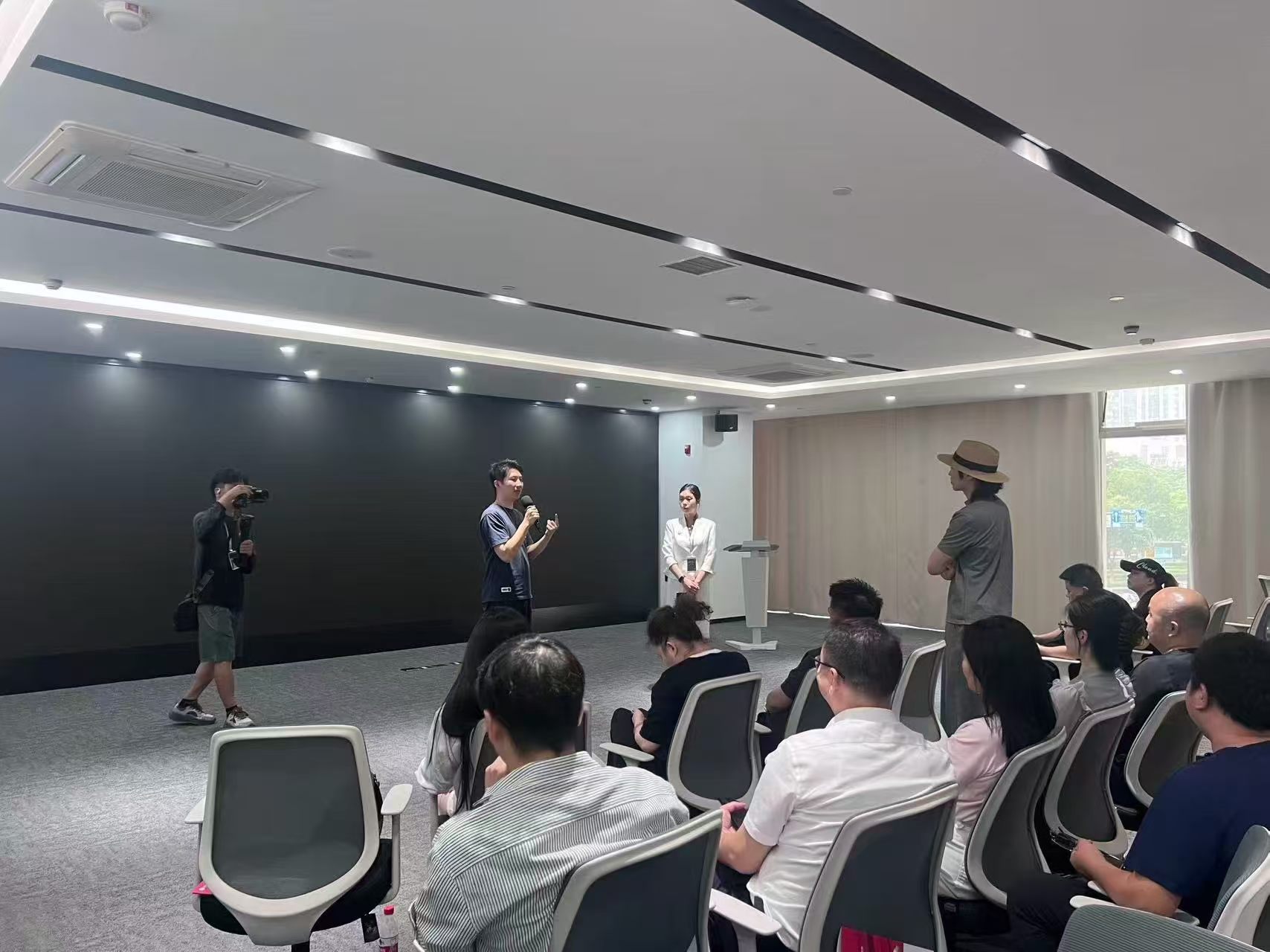 活动现场手持麦克风讲解 AI 产品落地经验